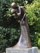 Bronzeskulptur Stehendes Liebespaar mit brauner Patina auf einer Säule im Garten 