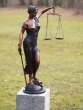 Bronzeskulptur Justitia stehend mit brauner Patina auf einer Säule im Garten 