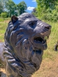 Bronzeskulptur ein Portallöwe auf einer Wiese von der Seite