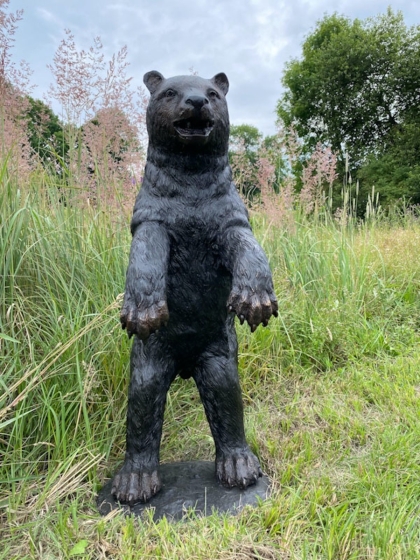 Bronzeskulptur Stehender Bär mit einer braunen Patina auf einer Wiese