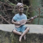 Bronzefigur Jan spielt auf seiner Gitarre im Garten 