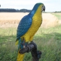 Bronzeskulptur "Farbenfroher blauer Papagei" auf Baumstamm