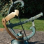 Bronze-Sonnenuhr im Halbkreis mit Pfeil und römischen Ziffern. Bronzefiguren und Gartenfiguren bei Kunsthandel Lohmann in Timmendorfer Strand.