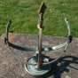 Bronze-Sonnenuhr im Halbkreis mit Pfeil und römischen Ziffern. Bronzefiguren und Gartenfiguren bei Kunsthandel Lohmann in Timmendorfer Strand.