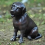 Bronzeskulptur Kleiner Sitzender Welpe im Garten mit brauner Patina