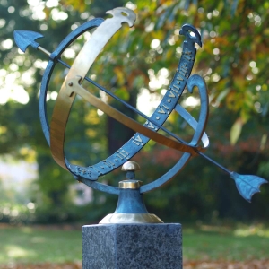 Bronzeskulptur Sonnenuhr mit grün-goldener Patina auf einer Säule im Garten 
