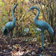 Bronzeskulptur Reiherpaar als Wasserspeier im Wald
