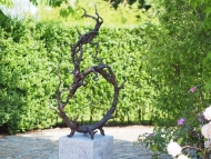 abstrakte Bronzeskulptur auf Granitsockel im Garten