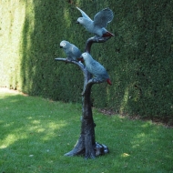 Graupapageien auf Baumstamm aus Bronze im Garten